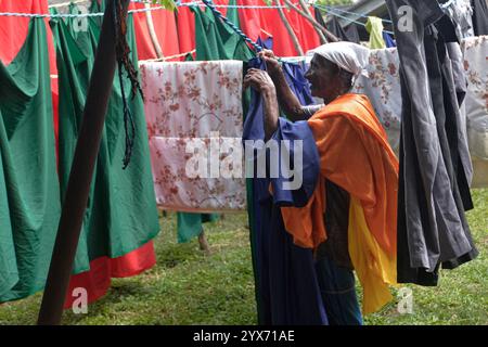 (241214) -- COLOMBO, 14. Dezember 2024 (Xinhua) -- Ein Arbeiter hängt am 13. Dezember 2024 Kleidung zum Trocknen an einer Wäscheleine in einer Gemeinde namens Laundrywatte in Colombo, Sri Lanka. In der Altstadt von Colombo, der Hauptstadt Sri Lankas, liegt eine Gemeinde namens Laundrywatte. Als Heimat von Generationen von Wäschearbeitern ist dieser Ort die letzte überlebende Wäschearbeitergemeinschaft in Colombo. Die Wäscherei in Sri Lanka hat eine Geschichte von etwa 100 Jahren. Die Arbeiter machen diese großräumige, zentralisierte Wäsche seit Generationen. Heute wird ihr Lebensunterhalt allmählich durch Waschen von m ersetzt Stockfoto