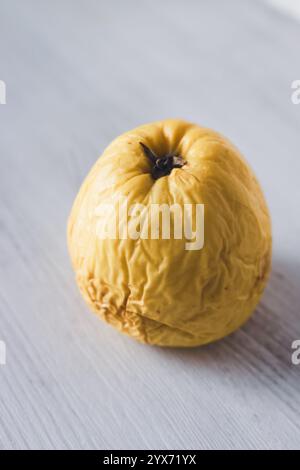 Verrotteter Apfel auf weißem Hintergrund. Gelber, faltiger Apfel. Konzept des Alterungsprozesses. Hautpflegekonzept. Verfall in der Natur. Zeitverlaufskonzept. Stockfoto