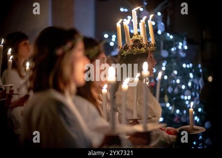 London, Großbritannien. Dezember 2024. Sankta-Lucia-Feiern des schwedischen Chors Norrsång East London in der St. Mary’s Church in Walthamstow. Alma Fridell Crawshaw trägt eine Kerzenkrone, die die hl. Lucy symbolisiert, während sie die Feier von Sankta Lucia leitet, basierend auf der Tapferkeit und dem Martyrium eines jungen sizilianischen Mädchens St. Lucy (Lucia von Syrakus 283–304). Guy Corbishley/Alamy Live News Stockfoto