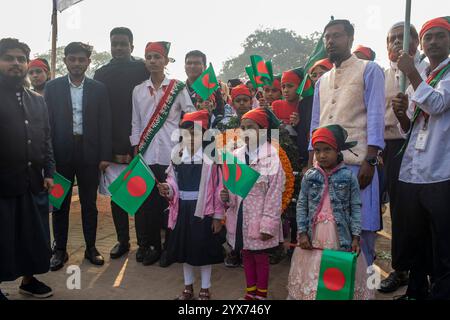 Dhaka, Bangladesch. Dezember 2024. Kinder halten Bangladesch-Flaggen während des Gedenktages der Märtyrer-Intellektuellen. Am Gedenktag der Märtyrer-Intellektuellen in Bangladesch werden zahlreiche bengalische Intellektuelle geehrt, die während des Befreiungskrieges in Bangladesch 1971 tragischerweise ihr Leben verloren haben. Diese Intellektuellen wurden von der pakistanischen Armee und ihren Verbündeten im gesamten ehemaligen Ostpakistan absichtlich angegriffen und brutal getötet, um die aufstrebende Nation durch die Ausrottung ihrer talentierten und intellektuellen Individuen zu untergraben. Quelle: SOPA Images Limited/Alamy Live News Stockfoto