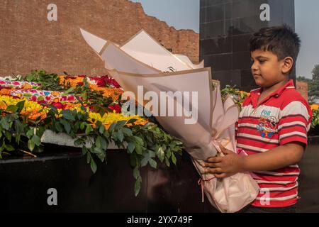 Dhaka, Bangladesch. Dezember 2024. Ein Junge hält während des Märtyrerdenkmals Blumen. Am Gedenktag der Märtyrer-Intellektuellen in Bangladesch werden zahlreiche bengalische Intellektuelle geehrt, die während des Befreiungskrieges in Bangladesch 1971 tragischerweise ihr Leben verloren haben. Diese Intellektuellen wurden von der pakistanischen Armee und ihren Verbündeten im gesamten ehemaligen Ostpakistan absichtlich angegriffen und brutal getötet, um die aufstrebende Nation durch die Ausrottung ihrer talentierten und intellektuellen Individuen zu untergraben. Quelle: SOPA Images Limited/Alamy Live News Stockfoto