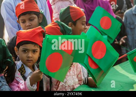 Dhaka, Bangladesch. Dezember 2024. Kinder halten Bangladesch-Flaggen während des Gedenktages der Märtyrer-Intellektuellen. Am Gedenktag der Märtyrer-Intellektuellen in Bangladesch werden zahlreiche bengalische Intellektuelle geehrt, die während des Befreiungskrieges in Bangladesch 1971 tragischerweise ihr Leben verloren haben. Diese Intellektuellen wurden von der pakistanischen Armee und ihren Verbündeten im gesamten ehemaligen Ostpakistan absichtlich angegriffen und brutal getötet, um die aufstrebende Nation durch die Ausrottung ihrer talentierten und intellektuellen Individuen zu untergraben. Quelle: SOPA Images Limited/Alamy Live News Stockfoto