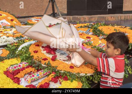 Dhaka, Bangladesch. Dezember 2024. Ein Junge hält während des Märtyrerdenkmals Blumen. Am Gedenktag der Märtyrer-Intellektuellen in Bangladesch werden zahlreiche bengalische Intellektuelle geehrt, die während des Befreiungskrieges in Bangladesch 1971 tragischerweise ihr Leben verloren haben. Diese Intellektuellen wurden von der pakistanischen Armee und ihren Verbündeten im gesamten ehemaligen Ostpakistan absichtlich angegriffen und brutal getötet, um die aufstrebende Nation durch die Ausrottung ihrer talentierten und intellektuellen Individuen zu untergraben. Quelle: SOPA Images Limited/Alamy Live News Stockfoto