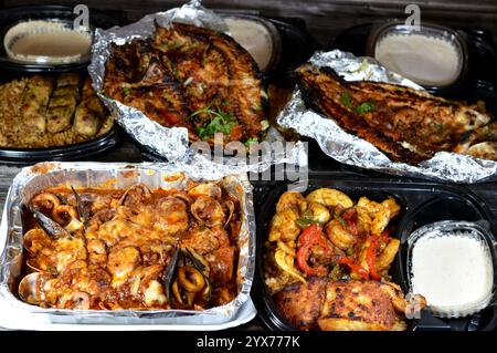 Fischküche mit gemischtem Fischfilet, Garnelen, Tintenfisch, Tintenfischeiern, Fischrogen, Muscheln, Muscheln, Krabben, rote Soße, Kräuter, Tilapia, Meeräsche Sinjari Fishes wi Stockfoto