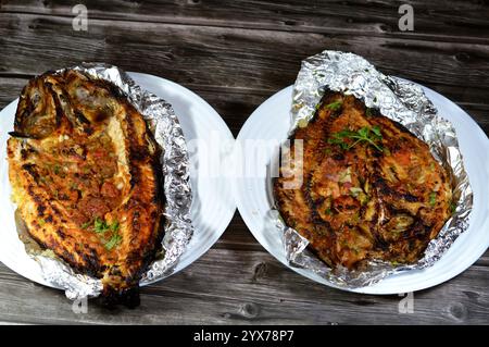 Tilapia, Meeräsche Sinjari, der Fisch wird geöffnet und mit Öl und Zitrone gegrillt oder im Ofen mit Gemüse Petersilie, Tomaten, Zwiebeln, Stockfoto