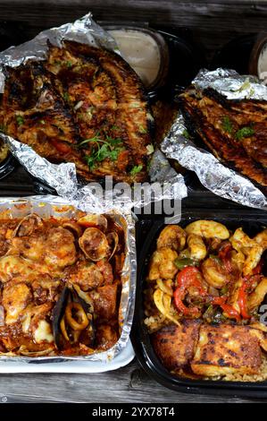 Fischküche mit gemischtem Fischfilet, Garnelen, Tintenfisch, Tintenfischeiern, Fischrogen, Muscheln, Muscheln, Krabben, rote Soße, Kräuter, Tilapia, Meeräsche Sinjari Fishes wi Stockfoto