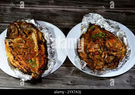 Tilapia, Meeräsche Sinjari, der Fisch wird geöffnet und mit Öl und Zitrone gegrillt oder im Ofen mit Gemüse Petersilie, Tomaten, Zwiebeln, Stockfoto