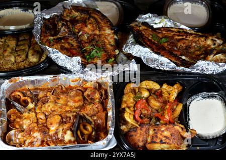 Fischküche mit gemischtem Fischfilet, Garnelen, Tintenfisch, Tintenfischeiern, Fischrogen, Muscheln, Muscheln, Krabben, rote Soße, Kräuter, Tilapia, Meeräsche Sinjari Fishes wi Stockfoto