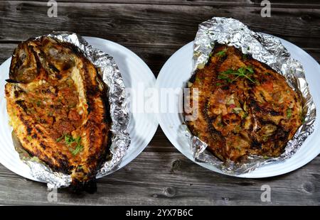 Tilapia, Meeräsche Sinjari, der Fisch wird geöffnet und mit Öl und Zitrone gegrillt oder im Ofen mit Gemüse Petersilie, Tomaten, Zwiebeln, Stockfoto