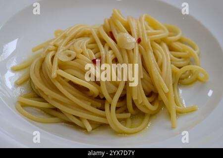 Spaghetti Colatura di Alici mit Knoblauch und Peperoncini auf einer weißen Platte Stockfoto