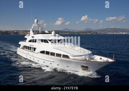 Luftbild einer Luxus-Motoryacht, die über den klaren blauen Ozean mit dem sonnigen Himmel im Hintergrund gleitet Stockfoto