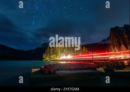 Nächtliche Szene des Emerald Lake mit hölzernem Lodge, Sternenhimmel und Kanu umgeben von felsigen Bergen im Yoho-Nationalpark, British Columbia, Kanada Stockfoto