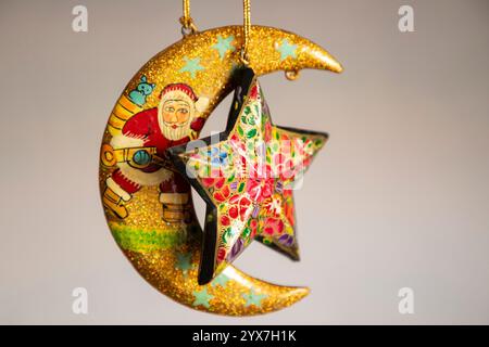 Weihnachtsschmuck, darunter die Figur des Weihnachtsmanns und ein Stern aus Pappe, der mâché in der Werkstatt vor den Weihnachtsfeiern gehängt wurde. Mit dem Vorweihnachtsanbruch sind die Handwerker aus Kashmiri Papier-mâché damit beschäftigt, verschiedene festliche Produkte und Ziergegenstände für den Export in die Vereinigten Staaten, Großbritannien, Frankreich, Deutschland und viele andere Teile der Welt zu veredeln. Künstler und Hersteller sagen jedoch, dass der russisch-ukrainische Krieg ihr Geschäft um 60 % reduziert hat und dass sie angesichts des anhaltenden Konflikts darum kämpfen, Aufträge zu erhalten. Diese geopolitischen Schwierigkeiten haben Kreation Stockfoto