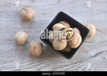 Gebackener knuspriger Walnussholz, abziehen und auf einer schwarzen Schüssel anordnen Stockfoto