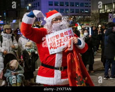 Ein als Weihnachtsmann verkleideter Demonstrant feiert die Amtsenthebung von Präsident Yoon Suk Yeol in der Nähe der Nationalversammlung in Seoul, Südkorea am Samstag, den 14. Dezember 2024. Yoon wurde wegen seines Kriegsrechtsversuchs mit 204 zu 85 Stimmen angeklagt. Foto: Thomas Maresca/UPI Credit: UPI/Alamy Live News Stockfoto