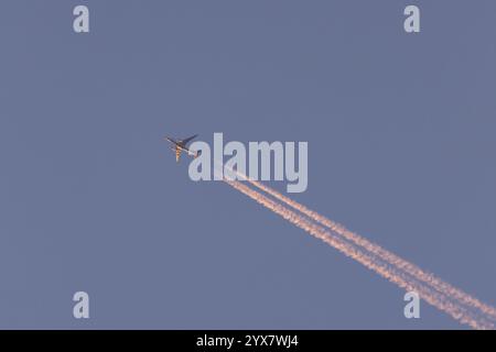 Boeing 767 Jet Cargo Flugzeug von FedEx fliegt in einem blauen Himmel mit Dampfspuren oder Kondensstreifen dahinter, England, Großbritannien, Europa Stockfoto