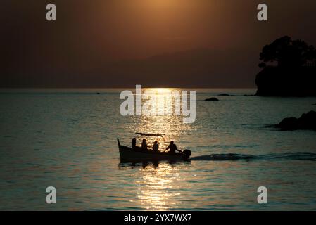 Leute auf einem Boot bei Sonnenuntergang. Stockfoto