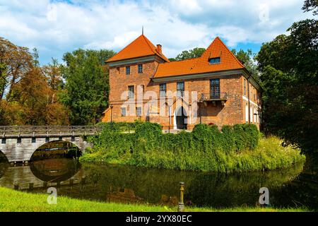 Oporow, Polen - 17. August 2024: Mittelalterliche Ritterburg Oporowskich mit nassem Graben und Zugbrücke im historischen Park im Dorf Oporow Stockfoto