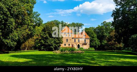 Oporow, Polen - 17. August 2024: Mittelalterliche Ritterburg Oporowskich mit nassem Graben und Zugbrücke im historischen Park im Dorf Oporow Stockfoto