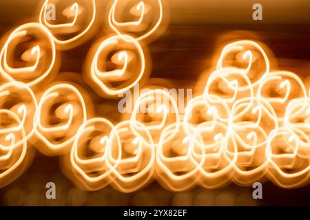 Energiegeladene Lichtspuren erzeugen ein faszinierendes abstraktes Muster auf einem lebhaften orangefarbenen Hintergrund, das für Projekte geeignet ist, die eine dynamische und farbenfrohe Sichtweise erfordern Stockfoto