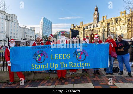 Leeds, Großbritannien. Dezember 2024. Leeds, Großbritannien, Leeds Stand Up to Rassismus halten ihre jährliche Mahnwache „Santa Knows no Borders“ im City Park in Leeds ab, wo sie Spenden für Flüchtlingshilfen entgegennahmen Credit: Neil Terry/Alamy Live News Stockfoto