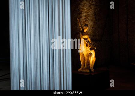 Ein Blick auf die Statue der „Nymphe mit Panther“ und die simulierte Rekonstruktion einiger Säulen des Domus Aurea. Nach jahrelanger Schließung im Zusammenhang mit den Maßnahmen zur Sicherung und Verbesserung der Nutzung des Denkmals eröffnet der Archäologische Park des Kolosseums den westlichen Teil von Neros Residenz (Domus-Gebiet) wieder und eröffnet den neuen Eingang in der Galerie XXIV. In Zusammenarbeit mit den Uffizien in Florenz wird bei diesem Anlass die Statue der sogenannten „Nymphe mit Panther“ ausgestellt. Stockfoto