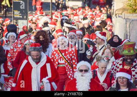 London, Großbritannien. Dezember 2024. Während des Santacon überqueren Revellers die Blackfriars Bridge. Jedes Jahr gehen Hunderte von Feiernden in Weihnachtsmannsverkleidungen auf eine Kneipenbummel im Zentrum von London. Quelle: Vuk Valcic/Alamy Live News Stockfoto