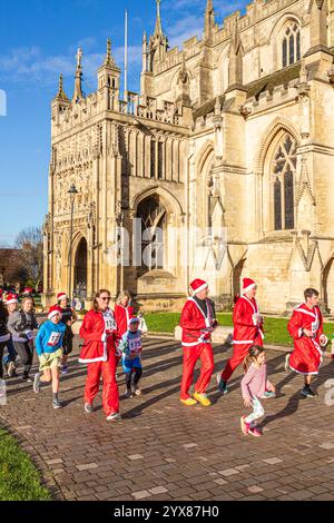 Einige der mehr als 600 Santas passieren die Kathedrale, während sie den Santa Fun Run laufen, der von Rotary International am 14./12/2024 in Gloucester, England U, organisiert wurde Stockfoto