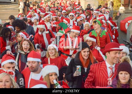 London, Großbritannien. Dezember 2024. Während des Santacon überqueren Revellers die Blackfriars Bridge. Jedes Jahr gehen Hunderte von Feiernden in Weihnachtsmannsverkleidungen auf eine Kneipenbummel im Zentrum von London. Quelle: Vuk Valcic/Alamy Live News Stockfoto