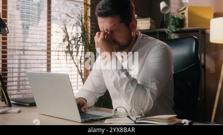 Kaukasischer Arbeiter Mann Geschäftsmann Angestellter arbeitender Laptop-pc im Büro männlicher Leiter Programmierer Brille entfernen Brille Corporate Guy Manager Gefühl Stockfoto