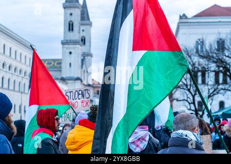 Pro-Palästina-Demo vor der Universität, Demonstrierende mit Palästina Fahnen, München, 14. Dezember 2024 Deutschland, München, 14. Dezember 2024, Pro-Palästina-Demo am Geschwister-Scholl-Platz vor der Universität, Ludwig-Maximilians-Universität, palästinensische Flaggen, im Durchblick die Ludwigskirche, , ca 100 Teilnehmer, meist Studierende, Motto der Demonstration von Campus zu Palestine: Student Voices will Never die, Protest der palästinensischen Studentenschaft gegen die deutsche Unterstützung Israels, gegen die israelische Politik in Gaza, wo schon Zehntausende bei Angriffen Stockfoto