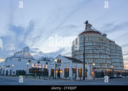 Der Magnolia Market und die Silos in der Innenstadt von Waco, Texas, sind für den Tag geschlossen, da die Sonne hinter dem Gebäude untergeht. Stockfoto