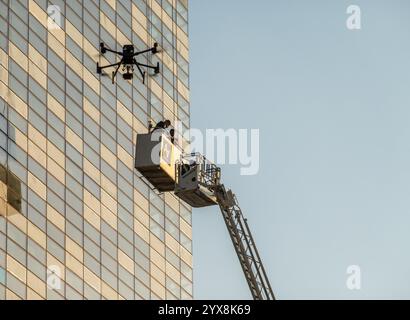 Amman, Jordanien - 12. November 2024: Drohnenüberwachung Rettung aus dem Hebezeug bei der Brandbekämpfung in einem modernen Bürogebäude Stockfoto
