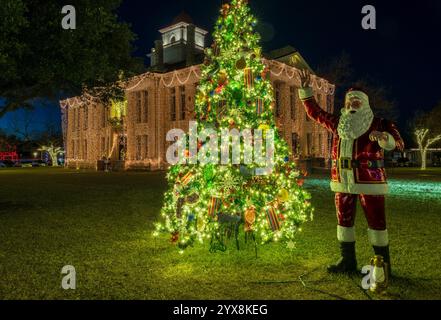 Funkelnde Lichter auf dem Weihnachtsbaum mit Santa-Statue rund um das Gerichtsgebäude jeden Dezember in Johnson City, Texas Stockfoto