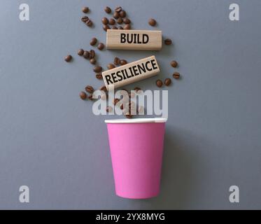Symbol für Belastbarkeit erstellen. Holzklötze mit Wörtern sorgen für Widerstandsfähigkeit. Schöner grauer Hintergrund mit Kaffeetasse. Business- und Build Resilience-Konzept. Stockfoto