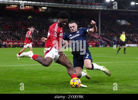 Nottingham Forest's Ola Aina (links) und Aston Villas John McGinn kämpfen um den Ball während des Premier League-Spiels auf dem City Ground in Nottingham. Bilddatum: Samstag, 14. Dezember 2024. Stockfoto