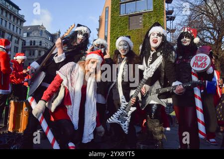 London, Großbritannien. Dezember 2024. Revelers, die als Rockband KISS verkleidet sind, nehmen an der diesjährigen SantaCon Teil. Jedes Jahr gehen Hunderte von Weihnachtsleuten in der Kleidung des Weihnachtsmanns auf eine Kneipenbummel im Zentrum von London, um Weihnachten zu feiern. Quelle: SOPA Images Limited/Alamy Live News Stockfoto