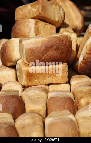 Stapel frisch gebackener Brotlaibe auf dem Tisch auf dem lokalen Markt Stockfoto