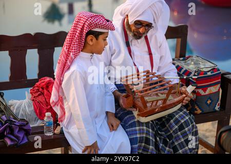 DOHA, KATAR - 13. Dezember 2024: Männer reiten auf Pferden, um den katarischen Nationalfeiertag zu feiern. Stockfoto