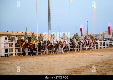 DOHA, KATAR - 13. Dezember 2024: Männer reiten auf Pferden, um den katarischen Nationalfeiertag zu feiern. Stockfoto
