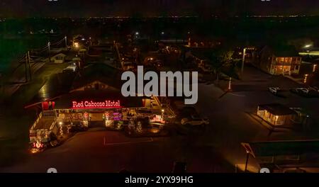 Ronks, Pennsylvania, USA, 7. Dezember 2024 - farbenfrohe Lichter zieren das Red Caboose Motel und schaffen nachts eine lebhafte Atmosphäre. Die festliche Dekoration in der Nähe unterstreicht den Charme dieses Reiseziels am Straßenrand Stockfoto