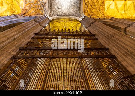 Kathedrale von Sevilla im Inneren des goldenen Altars des Hauptaltars. In der Kathedrale von Sevilla, Spanien mit eisernen Torstangen, Decke, Schiff, Altar. Stockfoto