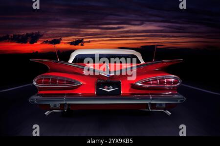 Rot 1959 Chevrolet Impala Convertible retro Oldtimer Rückansicht auf einer Autobahn in bunte rote Dämmerung nächtlichen Outdoor-Landschaft Stockfoto