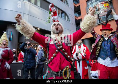 Ein Mann, der als Weihnachtsmann verkleidet ist, hebt die Arme. Hunderte von als Weihnachtsmann gekleideten Enthüllern nehmen an der Londoner Santa Con 2024 Teil. Mit seinen Anfängen in den Vereinigten Staaten ist Santa Con zu einem traditionellen Ereignis vor Weihnachten in London geworden. Die Santas-Parade beginnt zwei Wochen vor Weihnachten mit einem Kneipenbummel durch London, singen und schenken Zuschauern Geschenke. Während die überwiegende Mehrheit der Teilnehmer an Santa Con gutmütig und gut benommen ist, hat es in der Vergangenheit Trunkenheit und Gewalt gegeben. (Foto: James Willoughby/SOPA Images/SIPA USA) Stockfoto