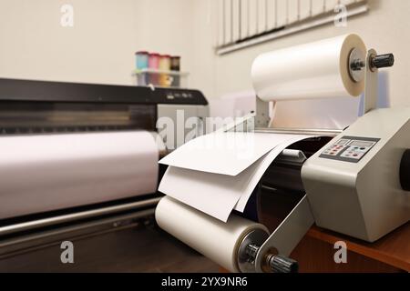 Modernes Laminiergerät mit Papier im Innenbereich. Druckerei Stockfoto