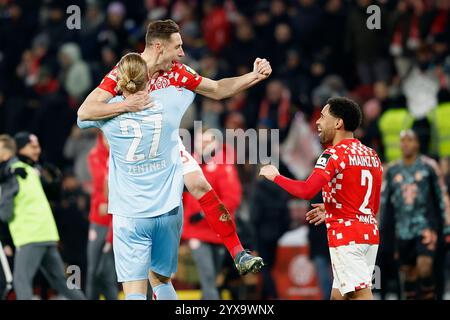 Mainz, Deutschland Dezember 2024. v.l.: Torwart Robin Zentner (1.FSV Mainz 05, 27), Dominik Kohr (1.FSV Mainz 05, 31) und Phillipp Mwene (1.FSV Mainz 05, 2) jubeln nach dem 2:1 gegen die Bayern. 14.12.2024, Fussball, Bundesliga, 1. FSV Mainz 05 - FC Bayern München, GER, Mainz, Mewa Arena, DFL-VORSCHRIFTEN VERBIETEN DIE VERWENDUNG VON FOTOGRAFIEN ALS BILDSEQUENZEN UND/ODER QUASI-VIDEO. Quelle: HMB Media/Alamy Live News Stockfoto