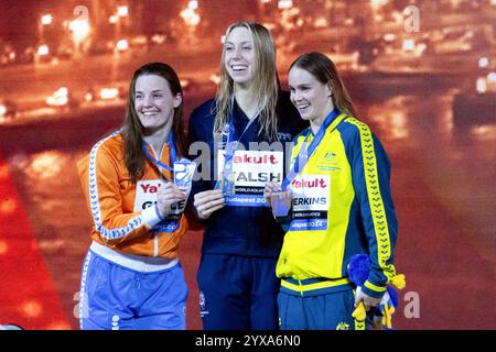 Budapest, Ungarn. Dezember 2024. Goldmedaillengewinner Gretchen Walsh (C) aus den Vereinigten Staaten, Silbermedaillengewinner Tessa Giele (L) aus den Niederlanden und Bronzemedaillengewinnerin Alexandria Perkins aus Australien posieren während der Verleihung des 100-m-Schmetterlings der Frauen bei der Weltmeisterschaft im Wassersport (25 m) in Budapest, Ungarn, 14. Dezember 2024. Quelle: Attila Volgyi/Xinhua/Alamy Live News Stockfoto