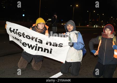 Klimaaktivisten blockieren die Straße, während sie während der Kundgebung ein Banner halten. Aktivisten der Bewegung der letzten Generation und Mitglieder anderer Organisationen veranstalteten einen fünfstündigen Bürgerprotest in Warschau, um einen Ort des anhaltenden zivilen Widerstands zu schaffen. Die Demonstration begann um 17:00 Uhr. Auf der Gdanski-Brücke wurde ein großes Banner mit der Aufschrift „Apocalypse Now“ ausgestellt, das auf Chris Niedenthals ikonisches Foto vom 13. Dezember 1981 verweist. „Vor einundvierzig Jahren, während der Einführung des Kriegsrechts, fürchteten sich die Menschen um ihre Zukunft in Polen. Proteste wurden gewaltsam unterdrückt, und mA Stockfoto