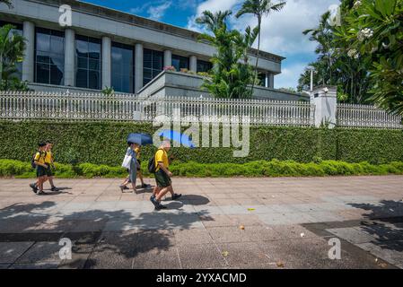Kinder der Junioren laufen entlang des Singapore River auf der Rückseite des Singapore Parliament Building Stockfoto