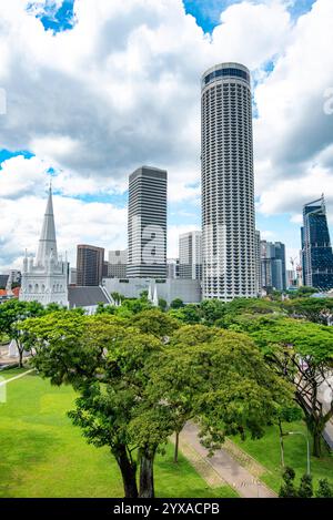 Von links nach rechts über das Gelände der St. Andrews Cathedral, das Raffles Hotel und das zylindrische Swissotel The Stamford Stockfoto